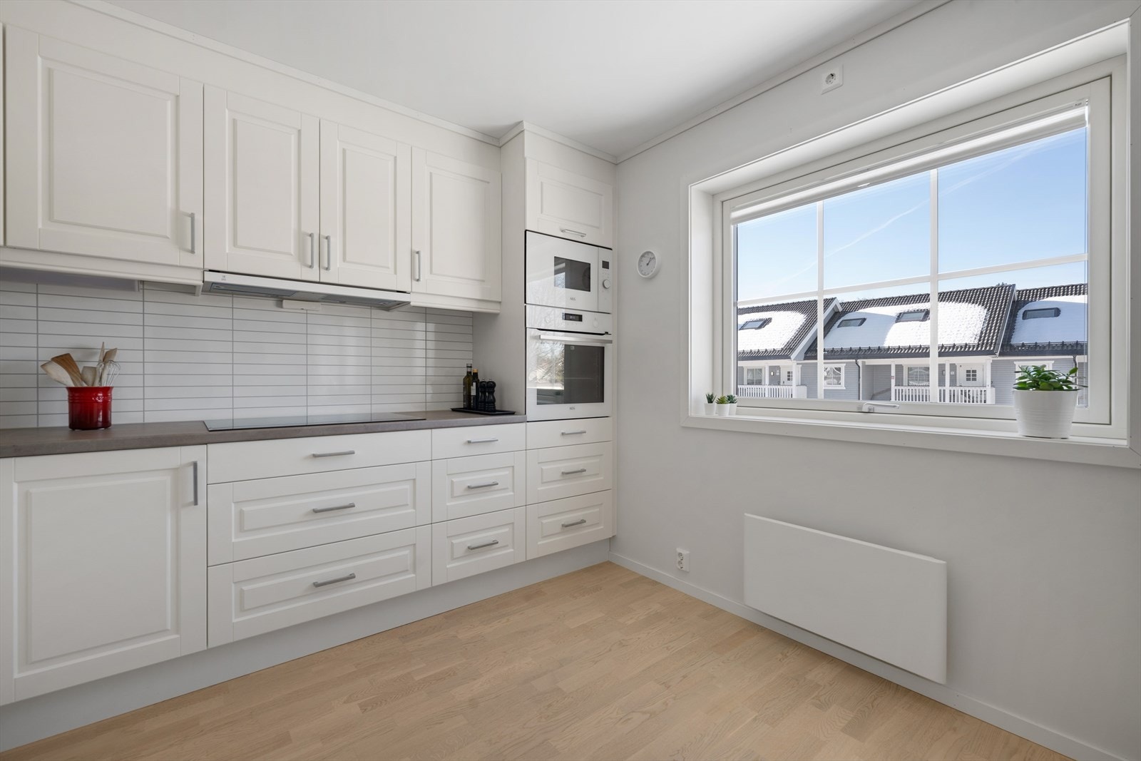 Kjøkken med hvit , profilert innredning og kitchenboard over kjøkkenbenk. Galleribilde