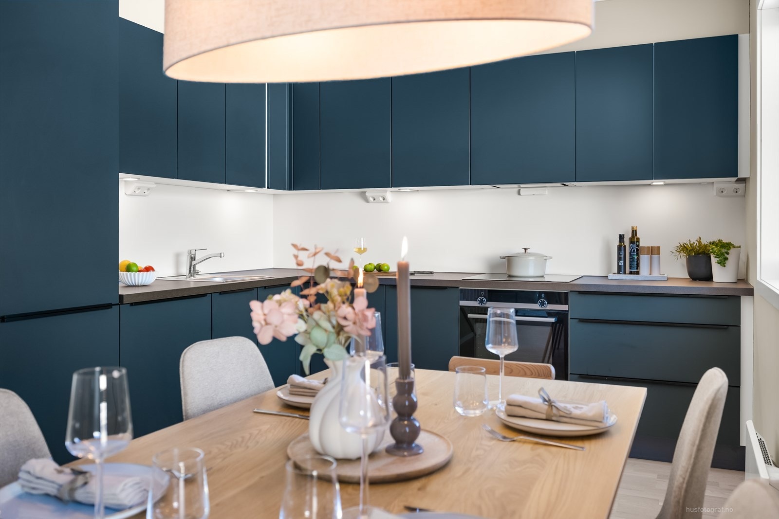 Moderne kjøkkeninnredning med slette blå fronter og benkeplate av laminat. Galleribilde