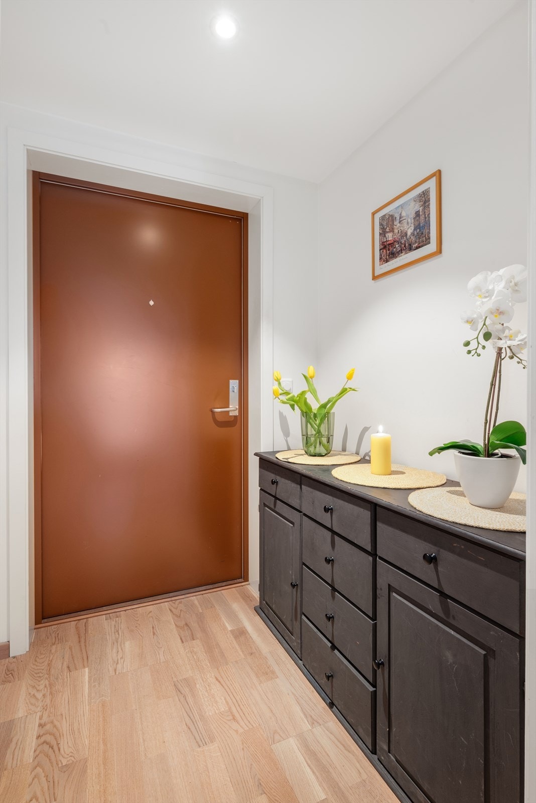 En innbydende entré med plass til oppheng av yttertøy og sko, ønsker deg velkommen inn i leiligheten. Galleribilde