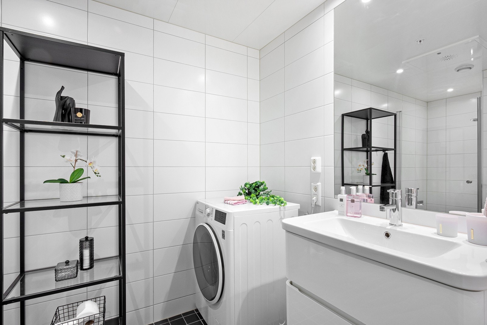 Badet ligger sentralt plassert i boligen og fremstår delikat med flislagte overflater, gulvvarme og downlights i himling. Galleribilde