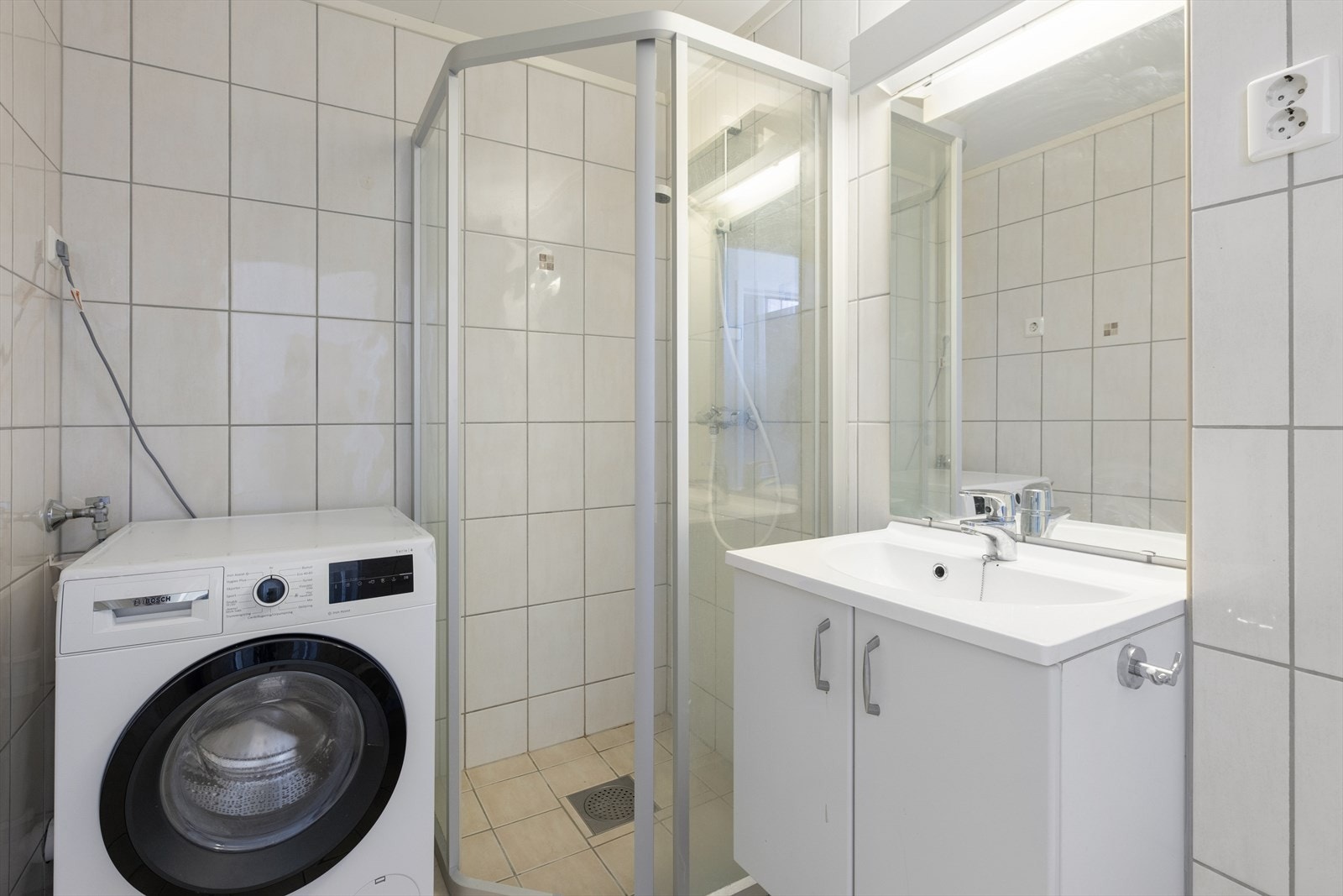 Innredningen består av speil, servantinnredning, vegghengt toalett, dusjhjørne og opplegg for vaskemaskin. Galleribilde