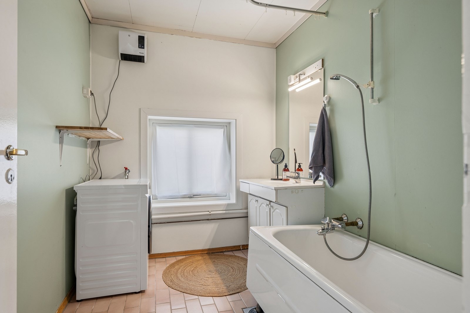 Badet har flislagt gulv, badekar, servantinnredning og opplegg for vaskemaskin. (Bad har fått TG3 av takstmann) Galleribilde