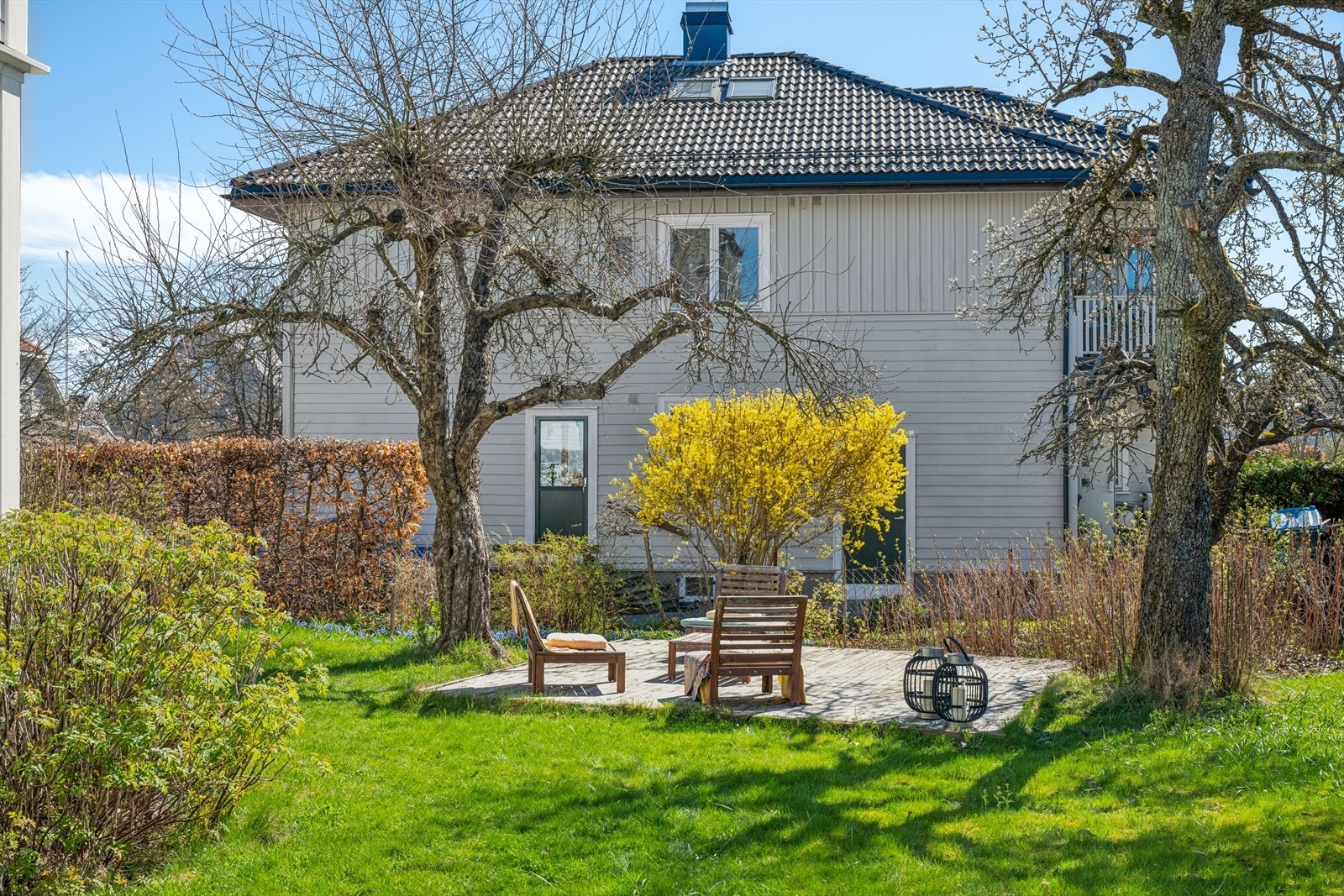 En veletablert hage med store trær omkranser eiendommen. Galleribilde
