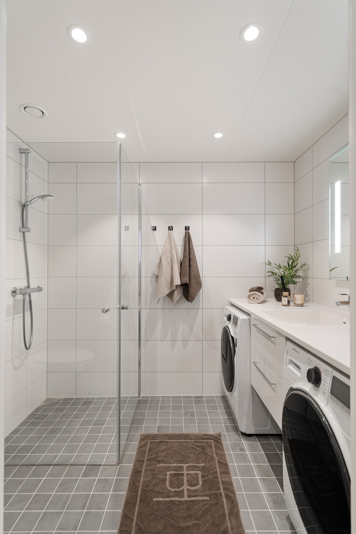 Badet er flott innredet med benkeplate over vaskemaskin og tørketrommel. Galleribilde