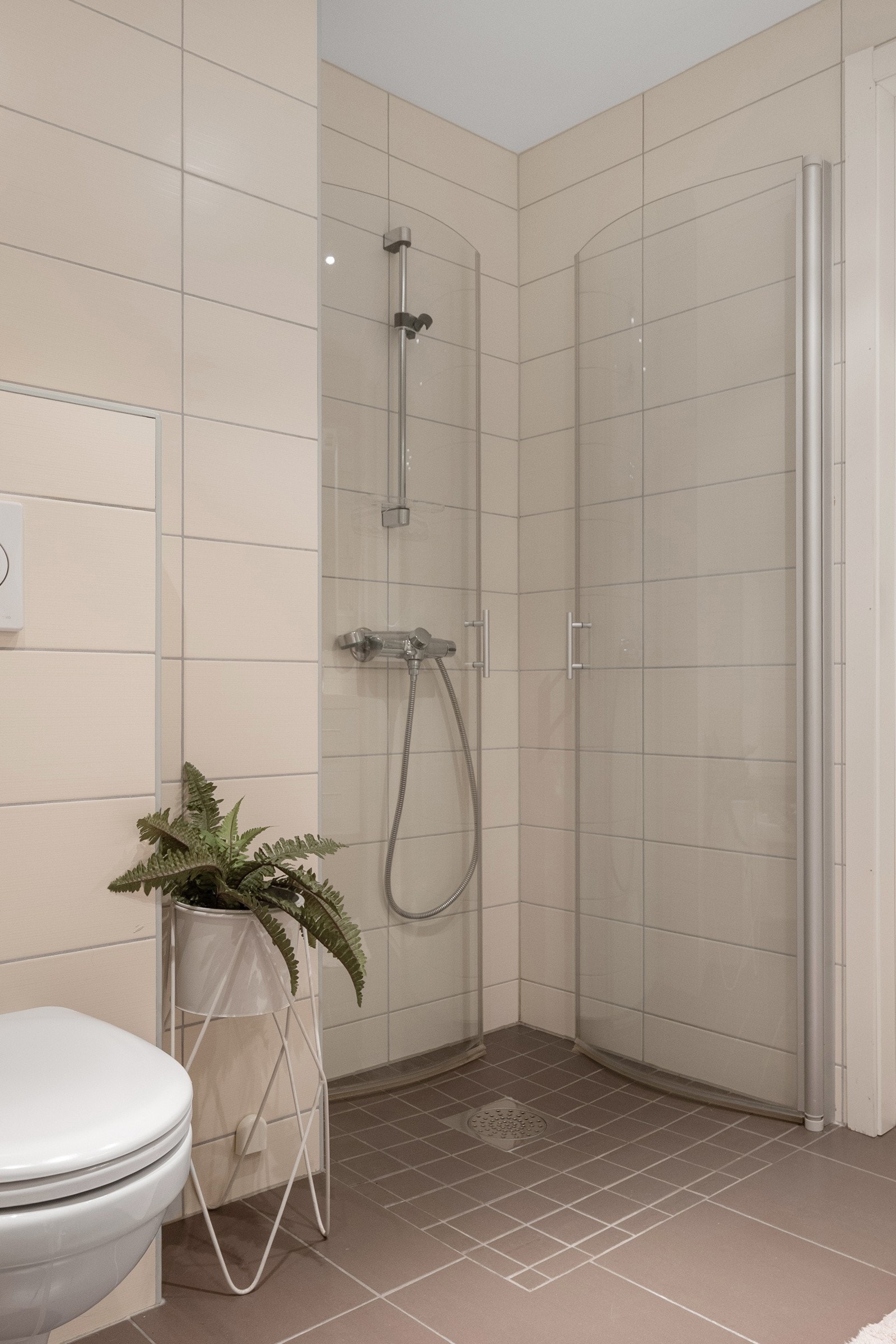 Badet er utstyrt med vegghengt toalett og dusjnisje med innfellbare glassdører. Galleribilde