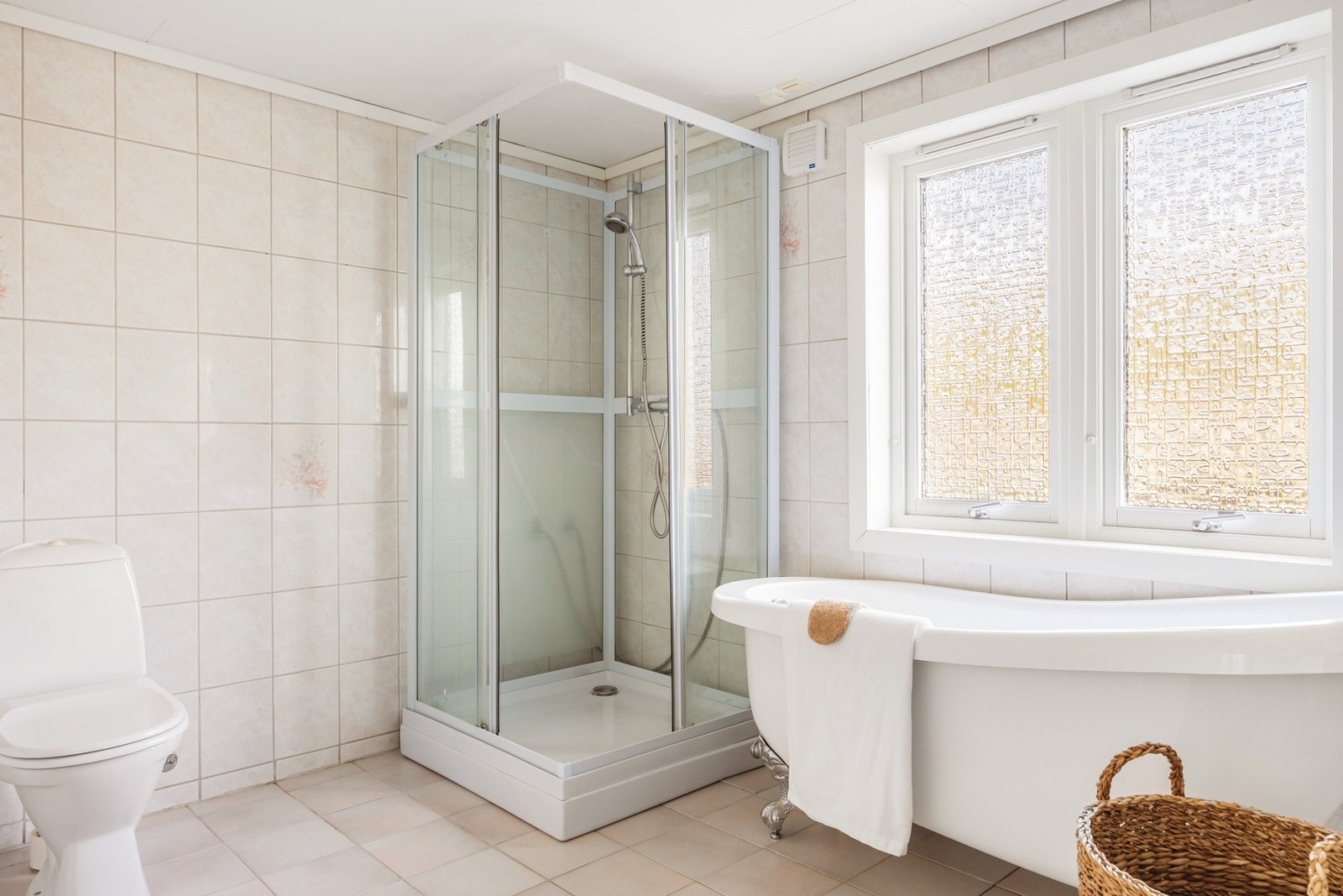 Badet er innredet med toalett, innredning med nedfelt servant, dusjkabinett, badekar og opplegg for vaskemaskin. Galleribilde