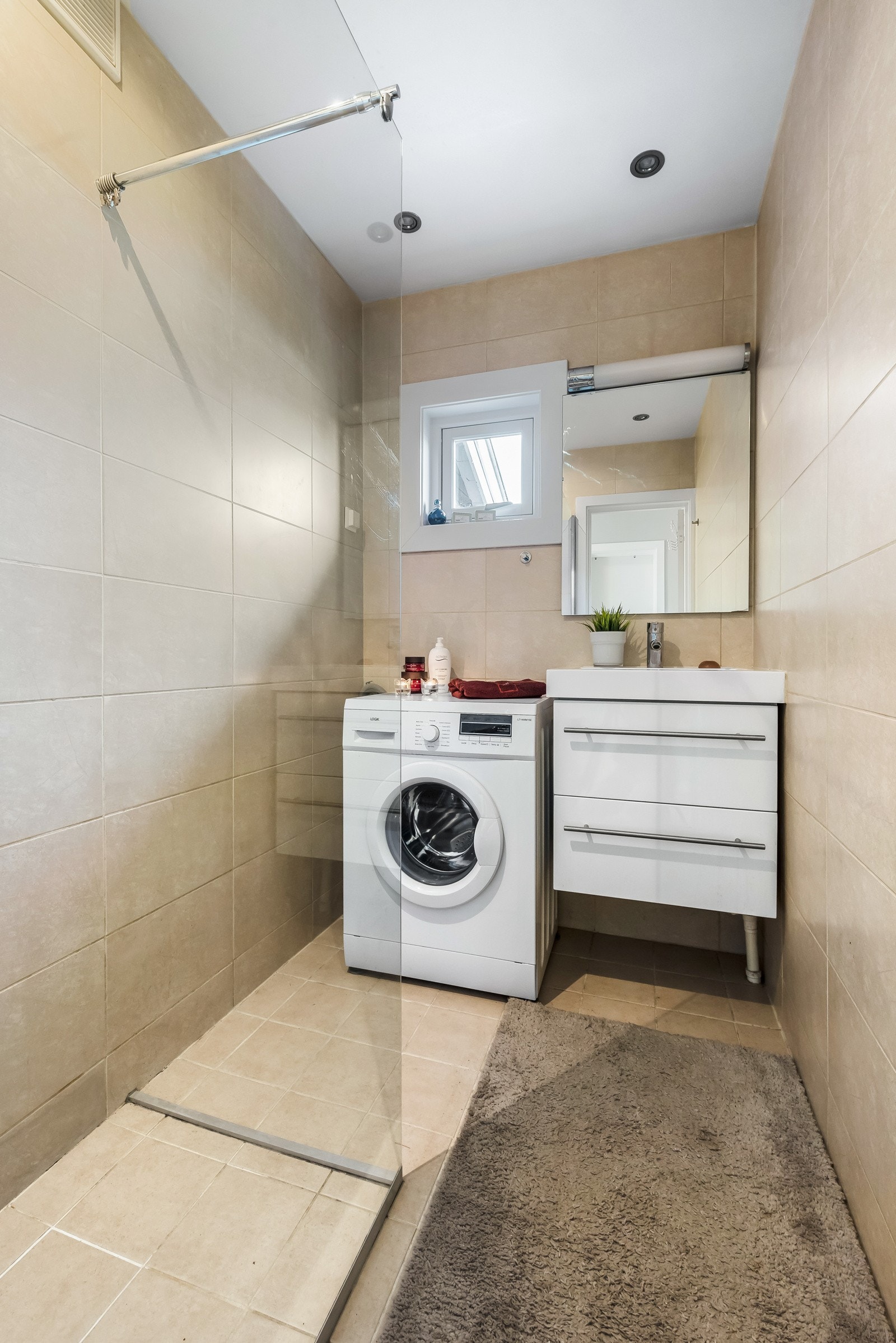 Badet har opplegg for vaskemaskin samt oppbevaringsmuligheter under servant. Vaskemaskin følger ikke med. Galleribilde