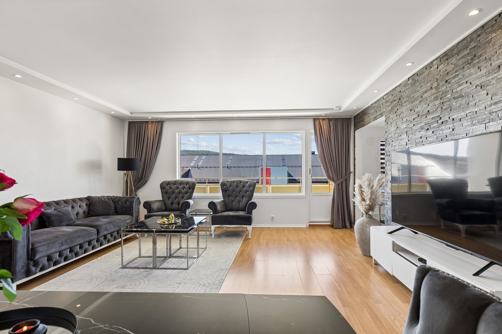 Lys og flott stue med slette overflater og downlights i tak. Galleribilde