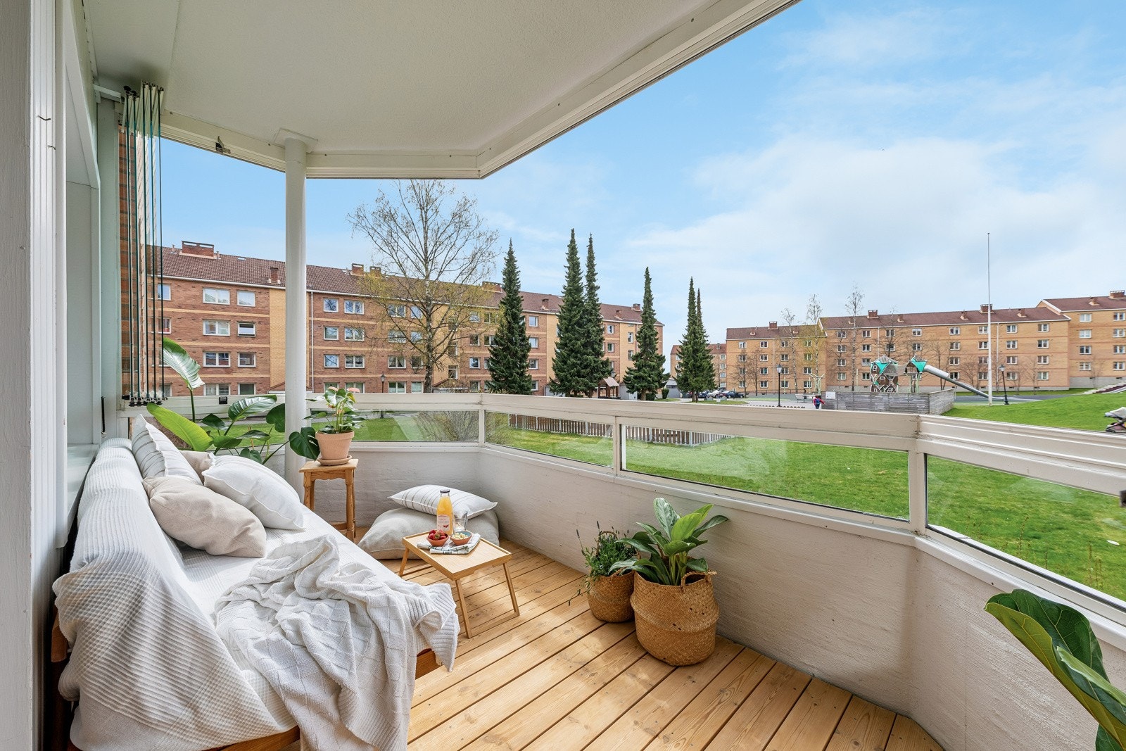 Nyt solrike dager og lune kvelder på egen balkong. Utsikt over borettslagets grønne lunge med god plass mellom blokkene. Galleribilde