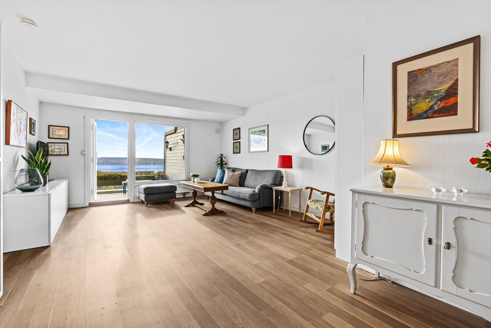 Fra entré trer du inn i boligens hjerte, en romslig og lys stue med store vindusflater som slipper inn rikelig med naturlig lys og fremhever det flotte utsynet mot sjøen. Galleribilde
