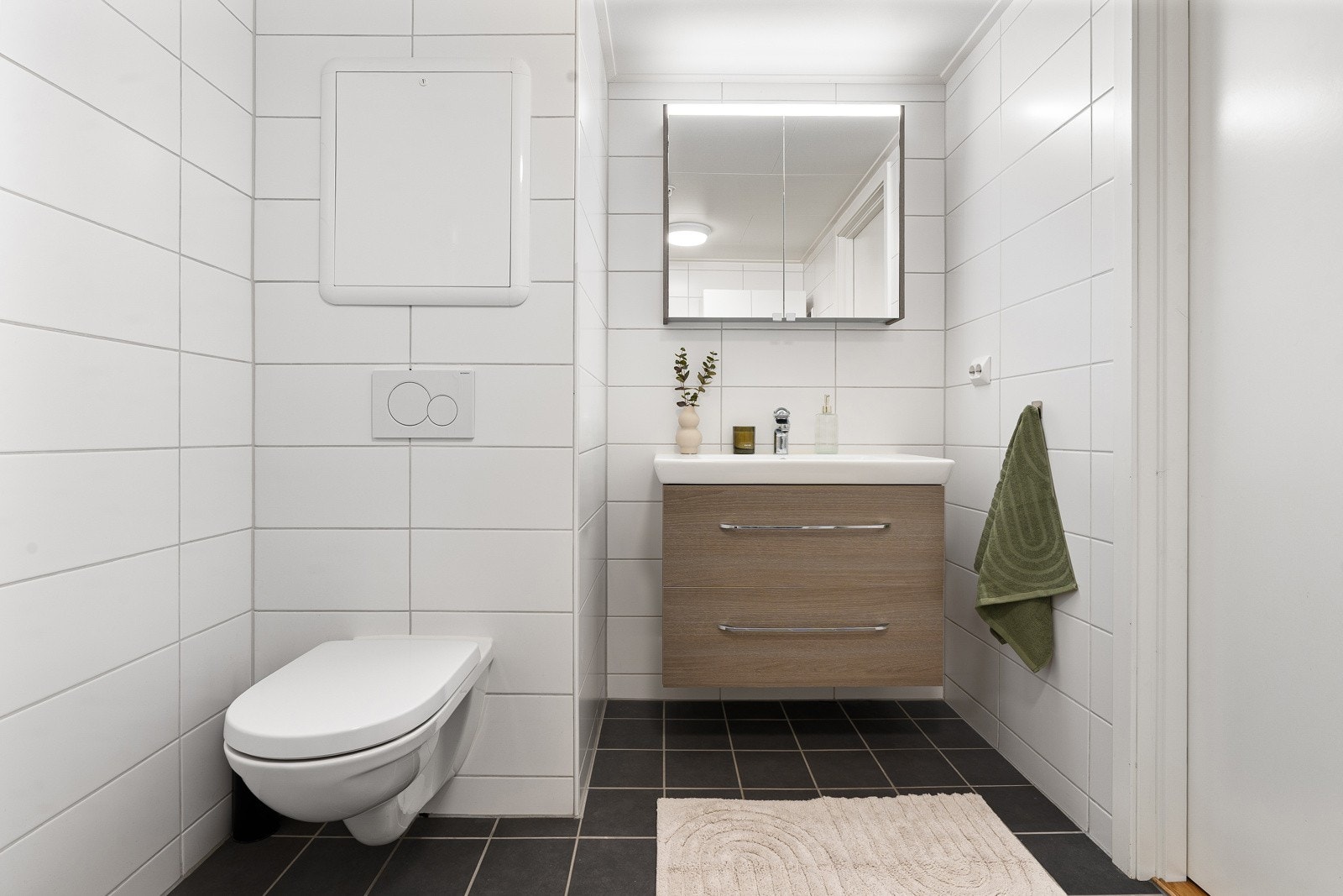 Innredning og speilskap for lagring av baderomsartikler.