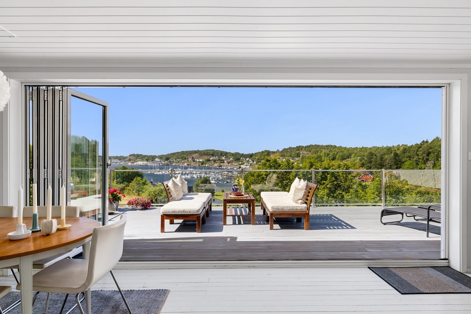 I stuesonen er det en bred foldedør i glass som kan skyves helt til side for å fjerne skillet mellom inne og ute. Galleribilde
