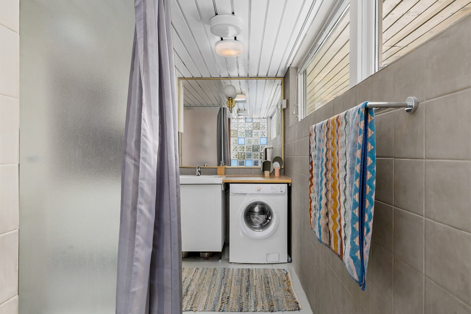 Badet har en dusjnisje og opplegg for vaskemaskin. Galleribilde