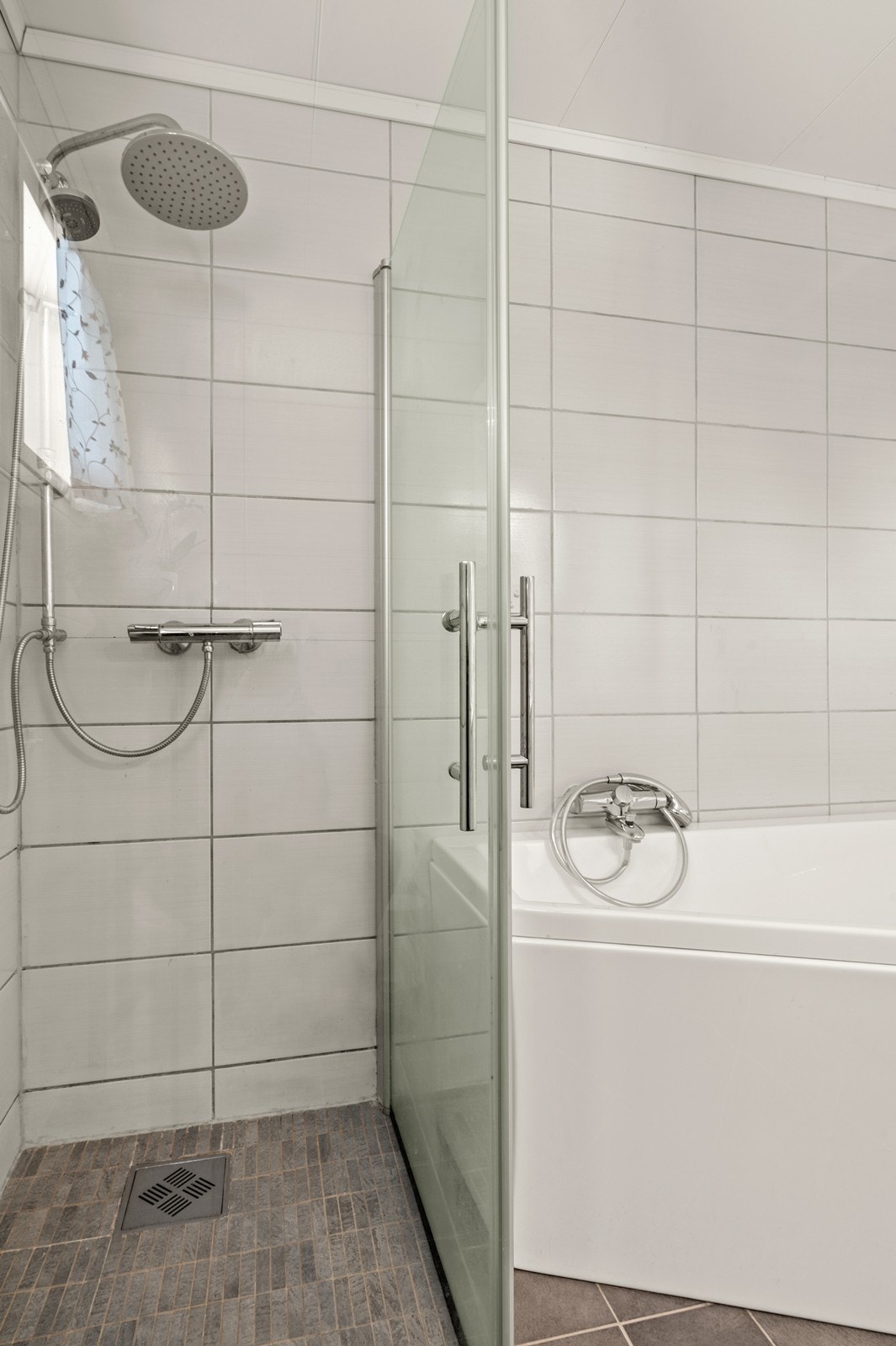 Badet er funksjonelt utstyrt med både åpen dusj med glassvegg og badekar. Galleribilde