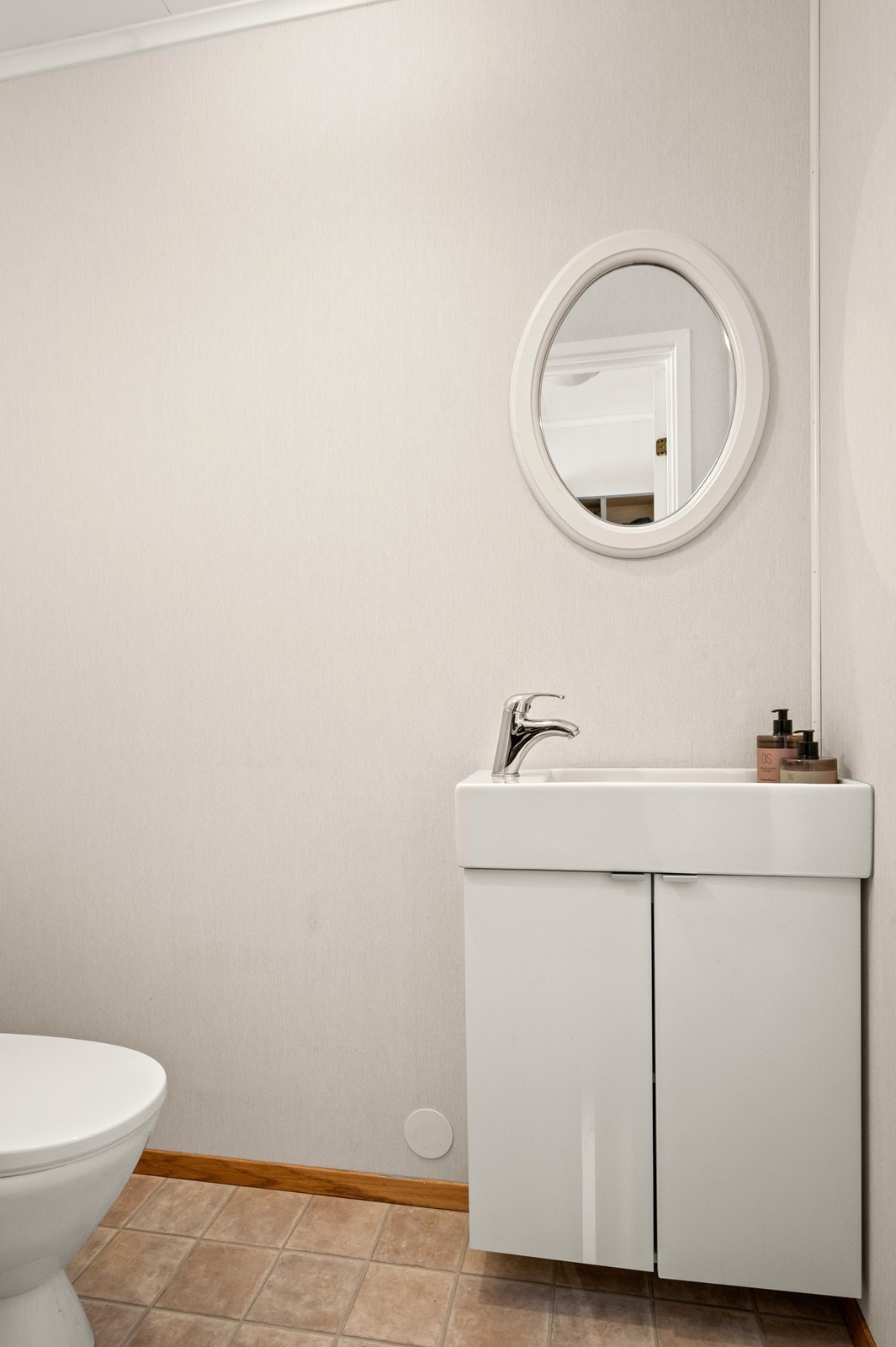 I første etasje finnes også et praktisk, separat toalettrom/gjestetoalett. Det er innredet med enkelt servantskap og gulvmontert toalett. Galleribilde
