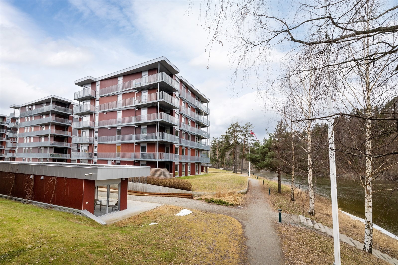 Tomten er pent opparbeidet med plen, beplantning og gangveier. Galleribilde