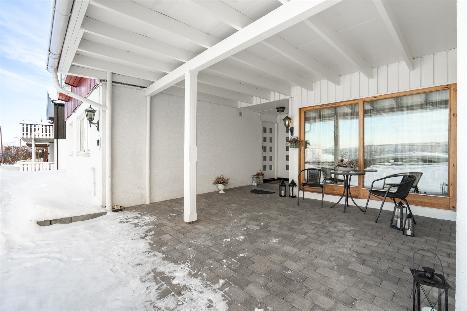 Innbydende inngangsparti med overbygg og brostensbelagt inngang, som gir praktisk le. Galleribilde