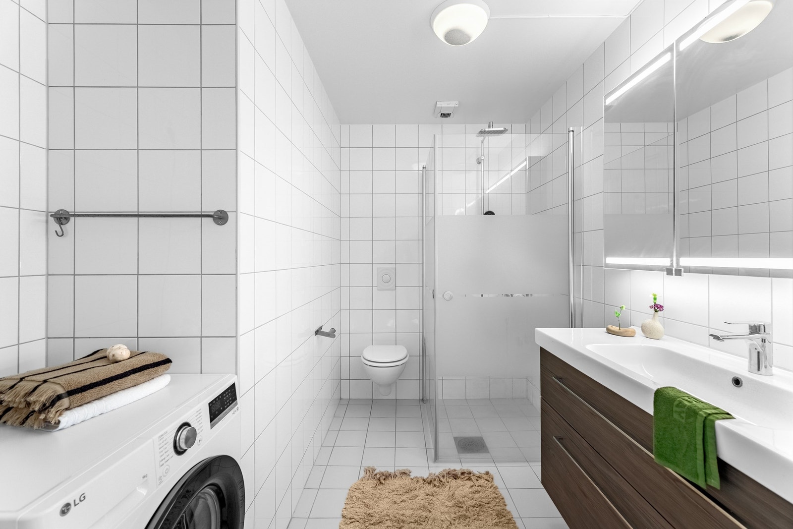 Pent fliselagt bad med gulvvarme og opplegg for vaskemaskin. Galleribilde