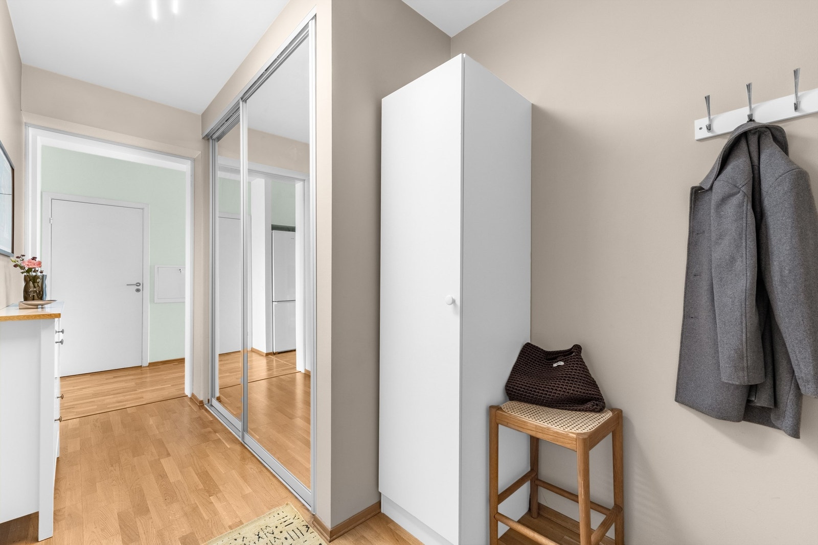Hyggelig og lys entré med plass til oppbevaring av yttertøy og sko i stor skyvedørsgarderobe med speilfronter. Galleribilde