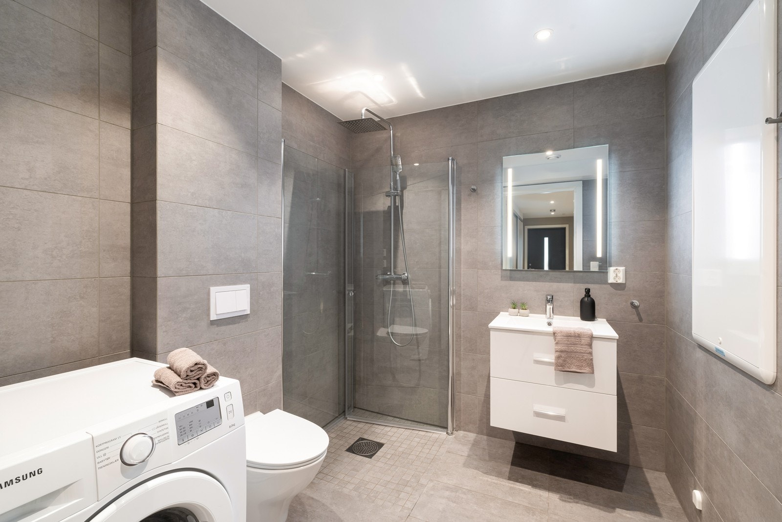 Pent, helfliset bad innredet med servant med skuffer og speil. Uttak til vaskemaskin på badet. Galleribilde