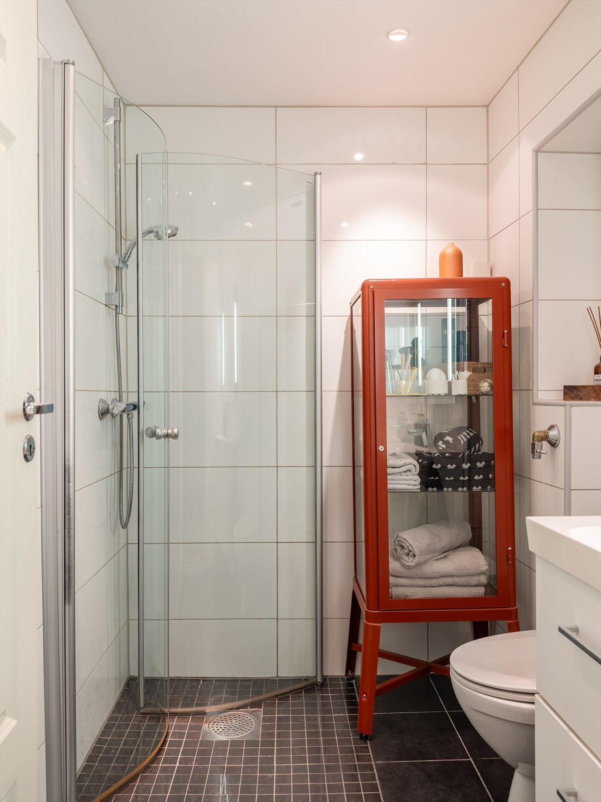 Badet byr på dusjhjørne med dører, gulvstående toalett og opplegg for vaskemaskin. Galleribilde