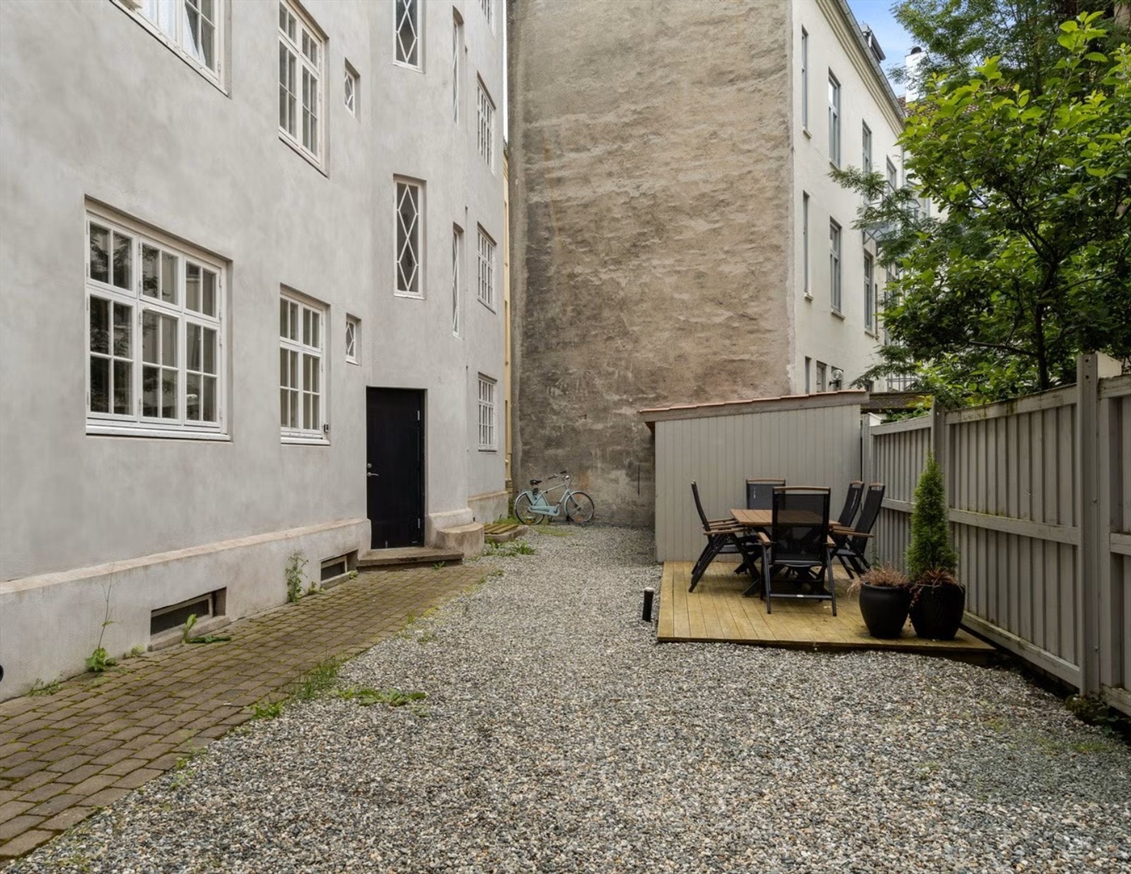 Koselig bakgård med sittegruppe for beboere, samt overbygd sykkelparkering Galleribilde