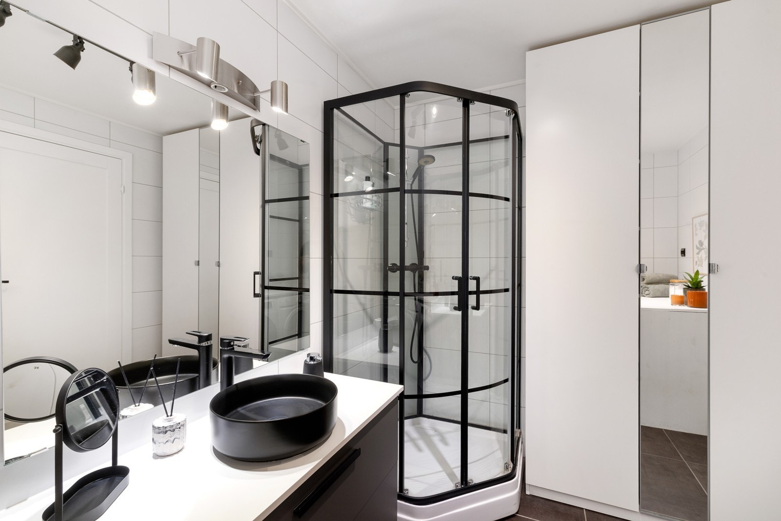 Leilighetens baderom er av god størrelse. Badet er flislagt med servant, dusjhjørne og vegghengt toalett. Baderommet er romslig med moderne valg og nyere innredning. Galleribilde