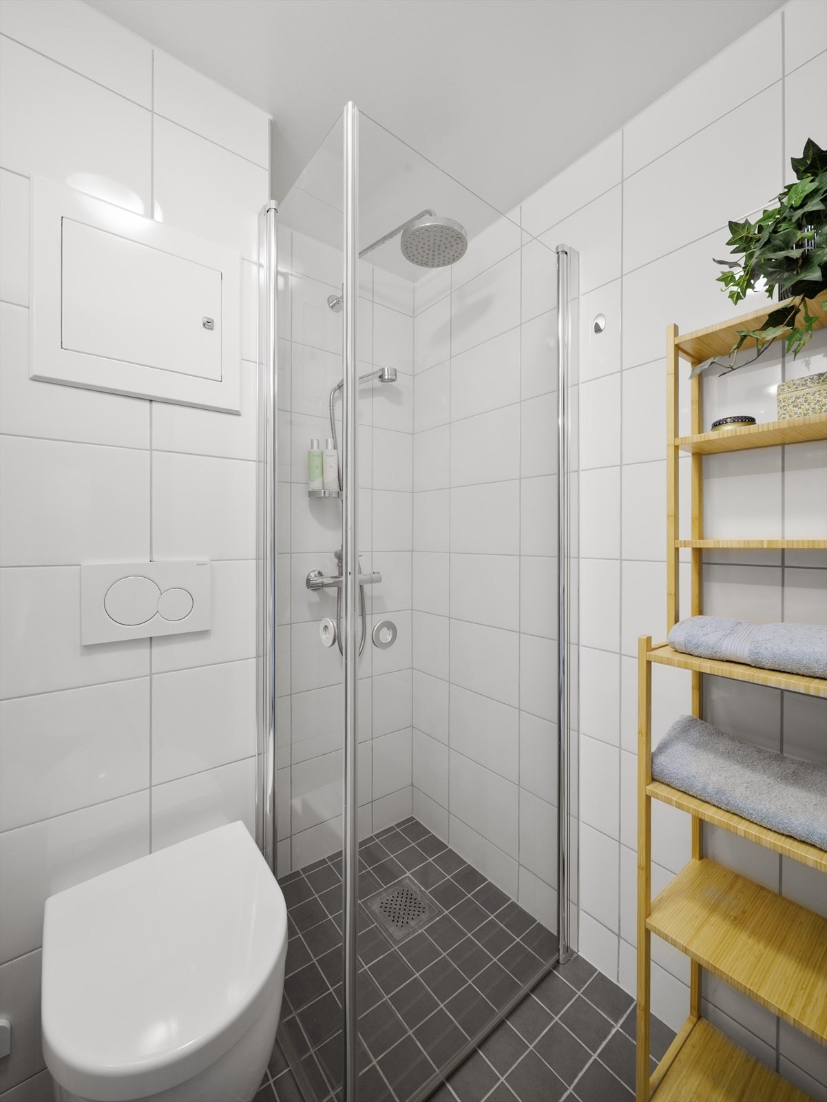 Badet inneholder vegghengt toalett, servant med skuffer, speilskap og rainshower-dusj. Galleribilde