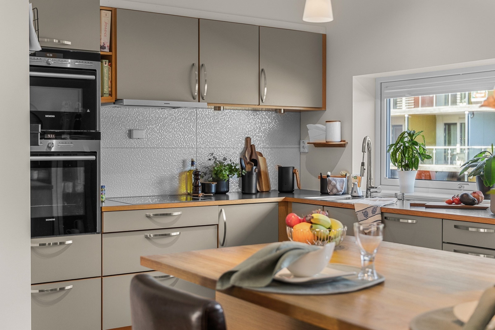 Moderne kjøkken med barløsning som skaper en naturlig overgang mellom kjøkken og stue. Galleribilde
