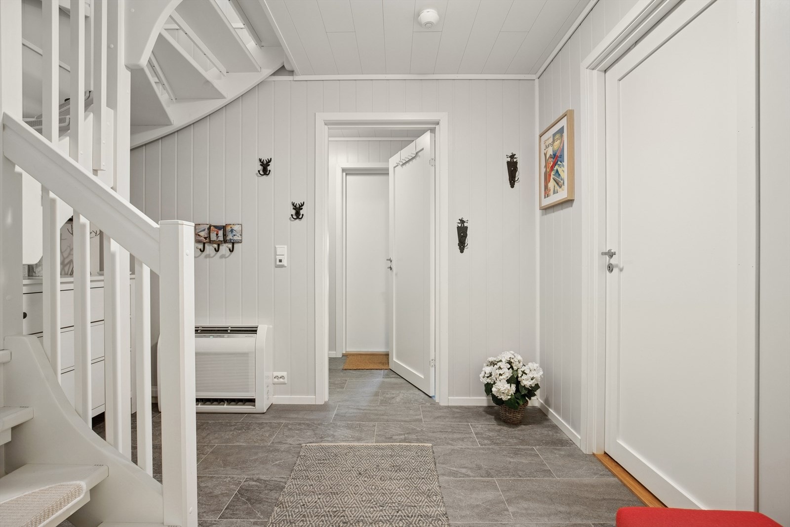 Her ønskes du velkommen inn i en romslig entré og videre inn i gang, begge med god plass til å henge fra seg ytterklær og sko. Varmekabler i entré og gang. Galleribilde