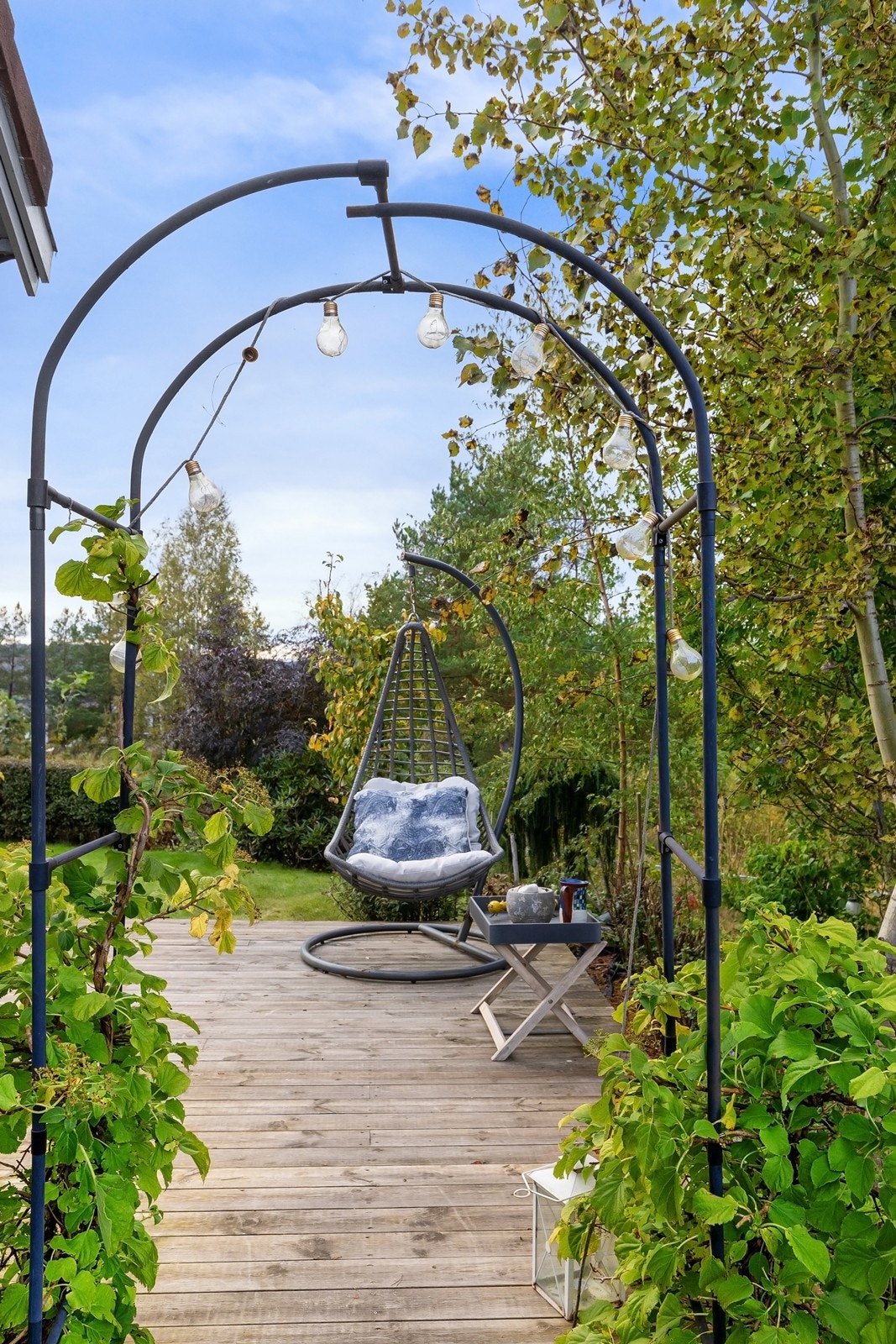 Hyggelig entré til terrasseplattingen med rosebue. Galleribilde