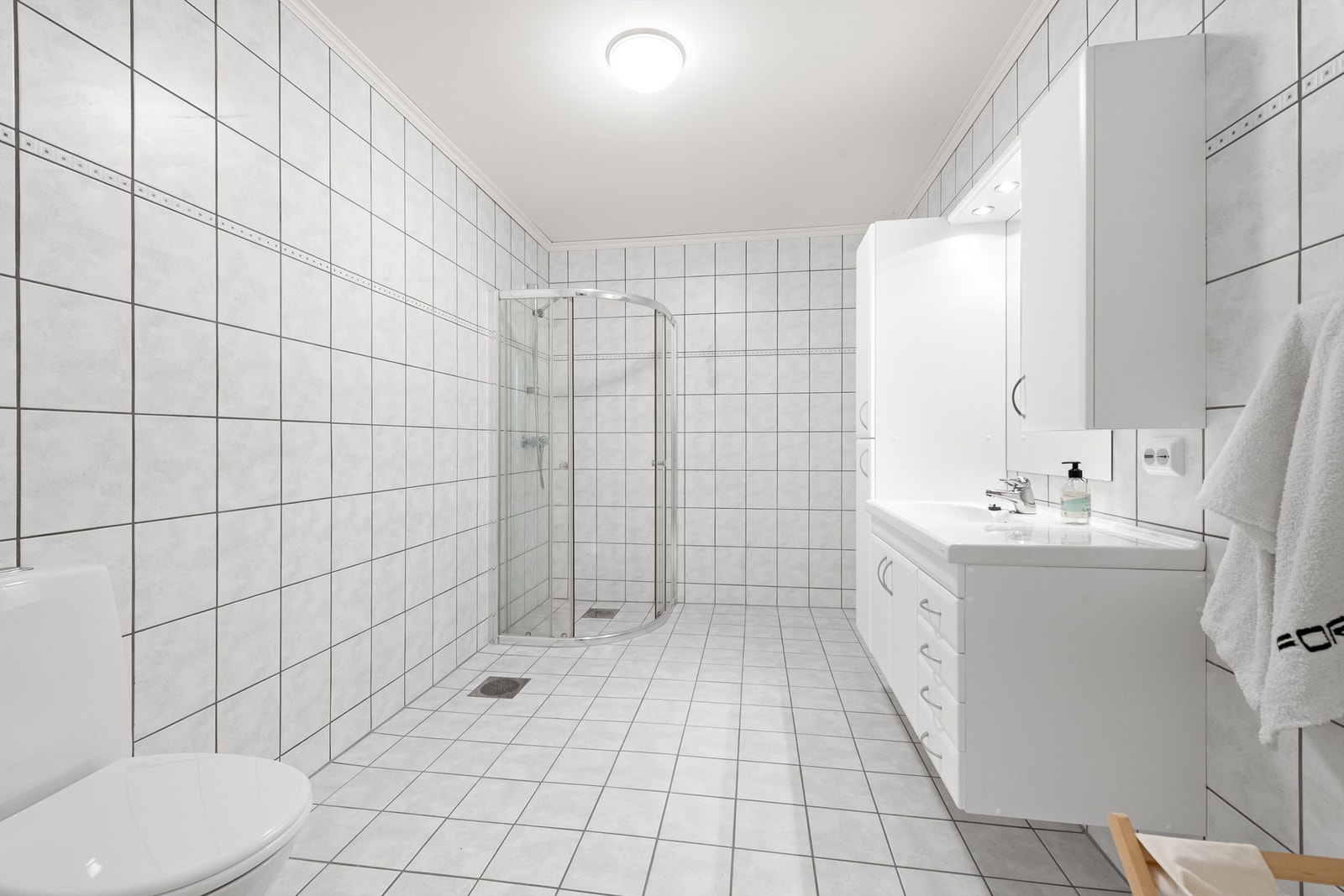 Badet i underetasjen tilhørende hoveddelen av boligen. Flislagt gulv med gulvvarme, flislagte vegger og stor og romslig innredning. Wc. Galleribilde