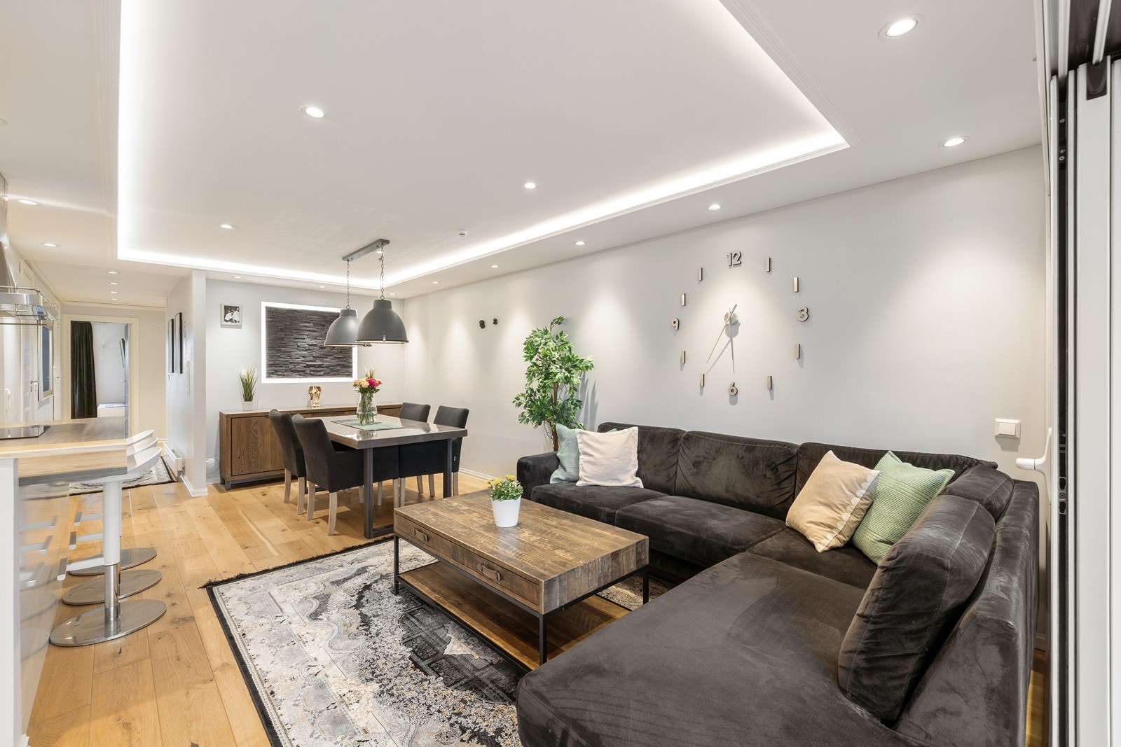 Rommet preges av et nedsenket tak med en kombinasjon av innfelte downlights og skjulte LED-striper, noe som skaper en eksklusiv atmosfære og en svært behagelig belysning. Galleribilde