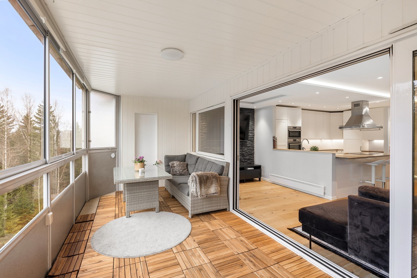Legg merke til den store skyvedøren som visker ut skillet mellom stuen og balkongen, og skaper en sømløs overgang mellom ute- og inneplass. Galleribilde