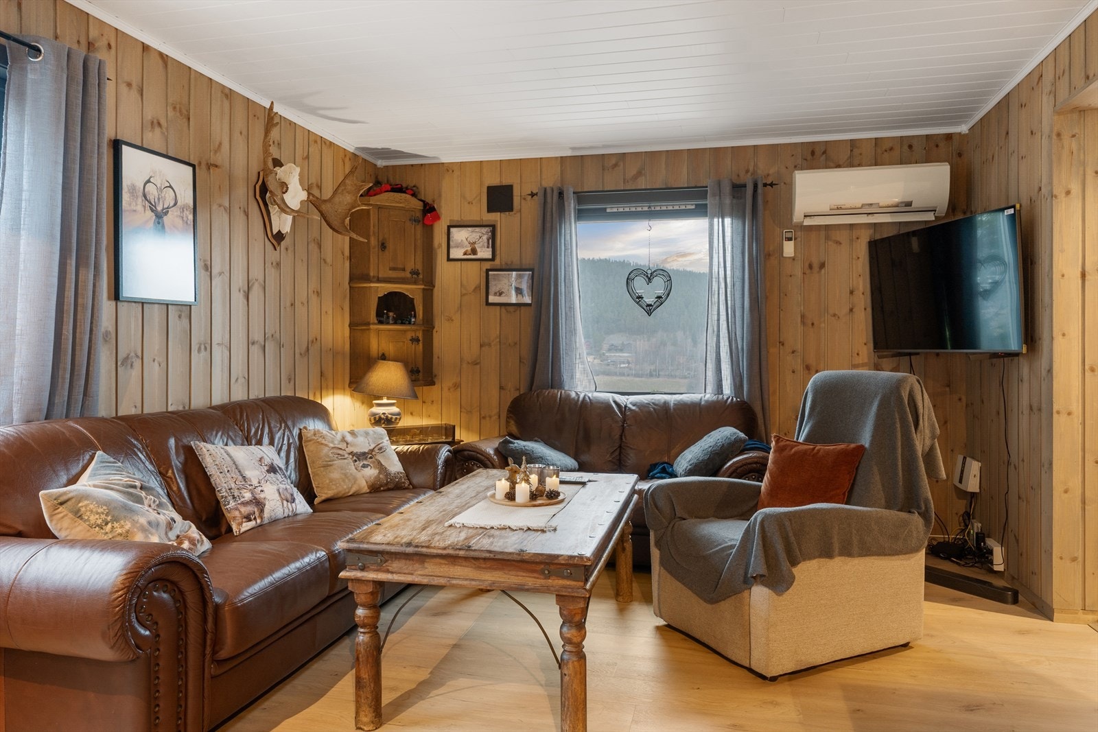 Vegger med beiset panel gir stuen en varm og tradisjonell karakter. Galleribilde