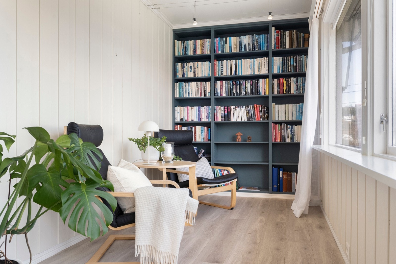 Deler av stuen er innredet som bibliotek. Ett koselig sted å trekke seg tilbake. Galleribilde