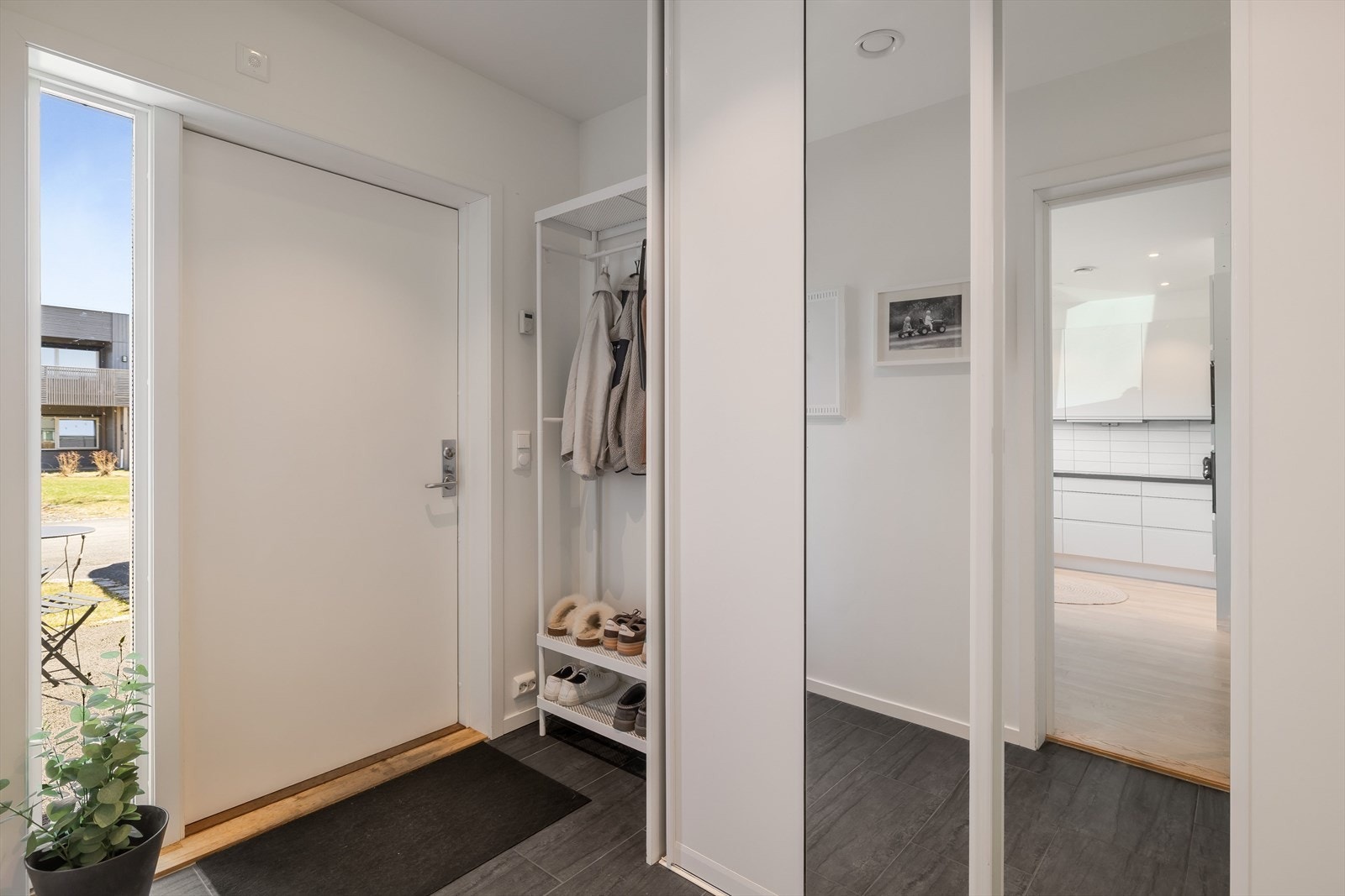 Entréen har flislagt gulv og skyvedørsgarderobe for praktisk oppbevaring. Galleribilde