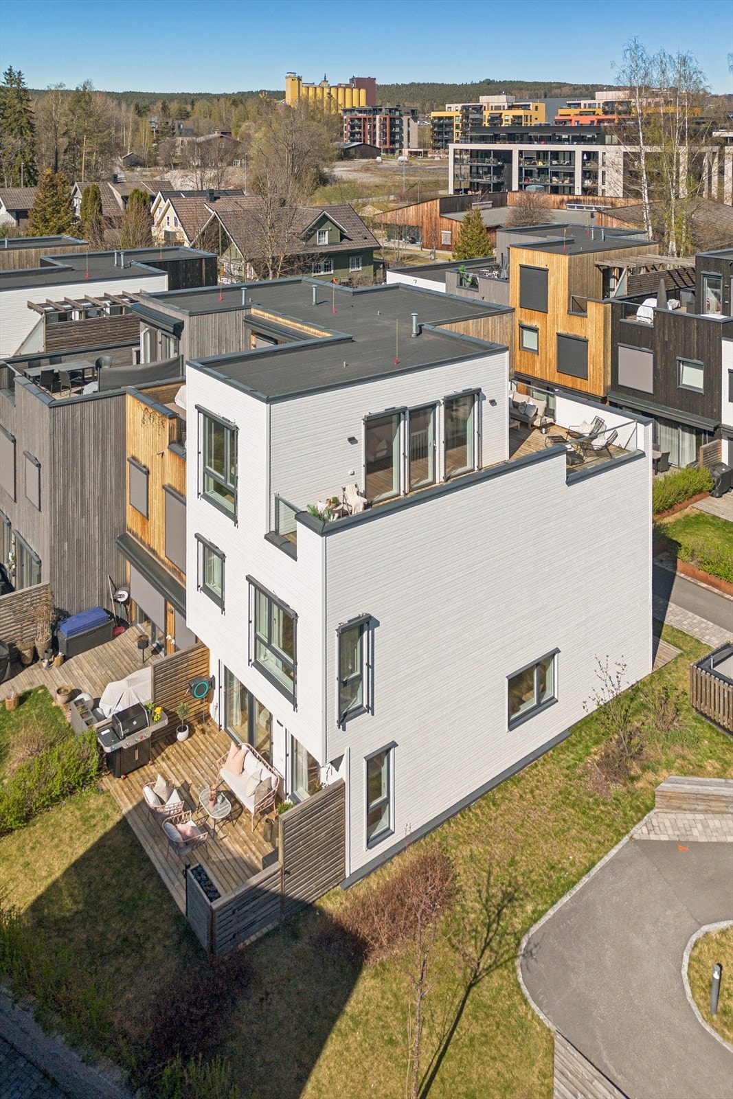 Rekkehuset har en moderne funkis-arkitektur med en kombinasjon av stående og liggende trekledning. Galleribilde