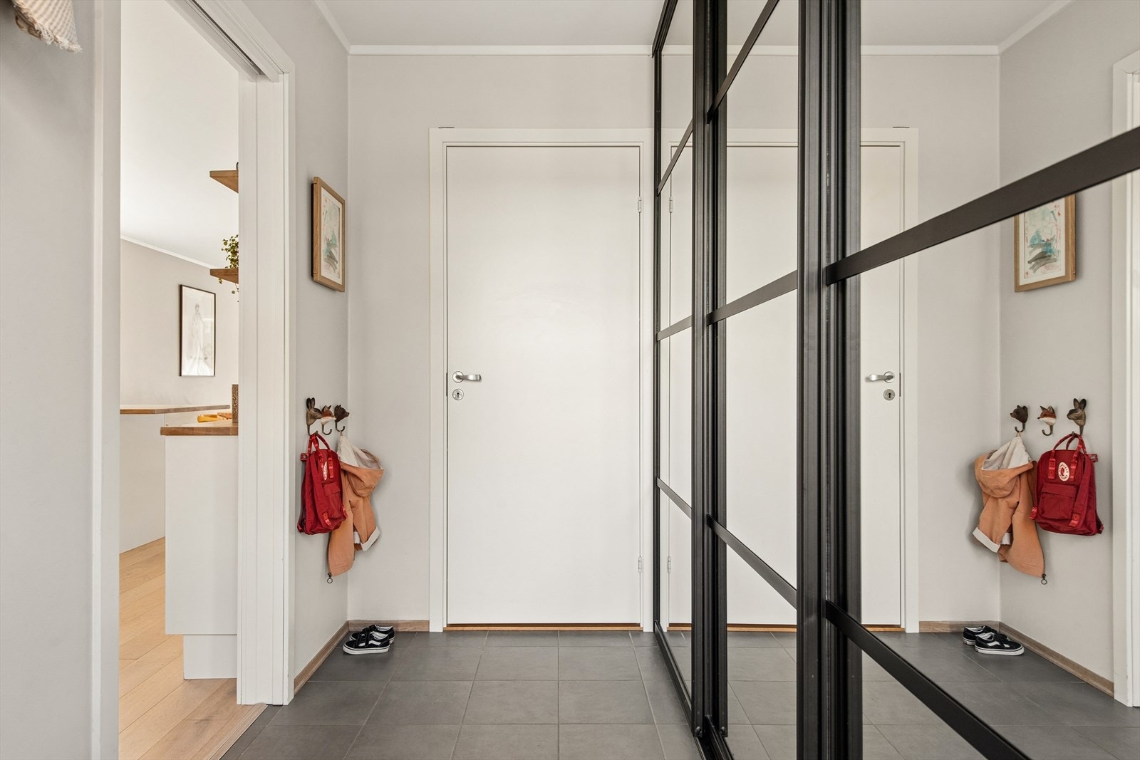 Entréen har flislagt gulv med vannbåren gulvvarme og praktisk skyvedørsgarderobe. Galleribilde
