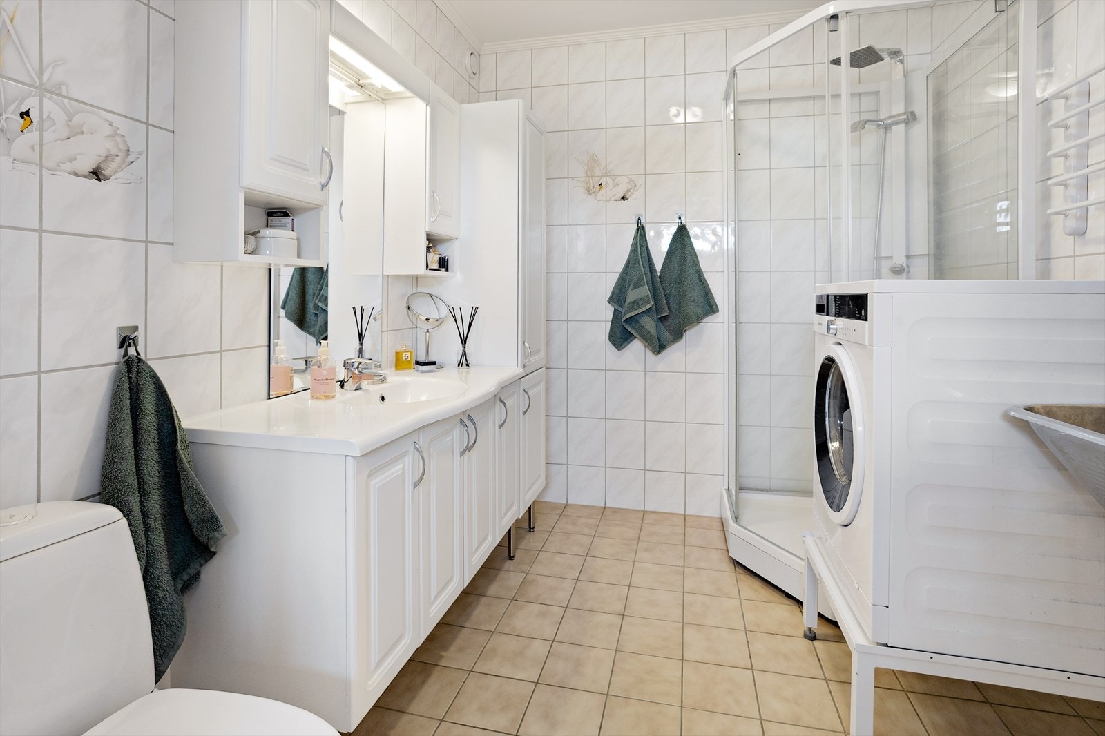 Badet har fliser på gulv og vegger, samt malt innvendig tak. Det er elektriske varmekabler i gulv som sørger for god komfort året rundt. Galleribilde