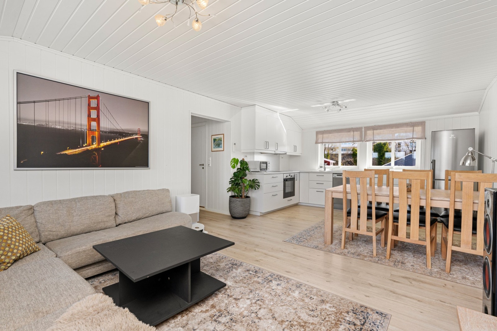 Lys og romslig stue med naturlig flyt mot spiseplass og kjøkken. Galleribilde