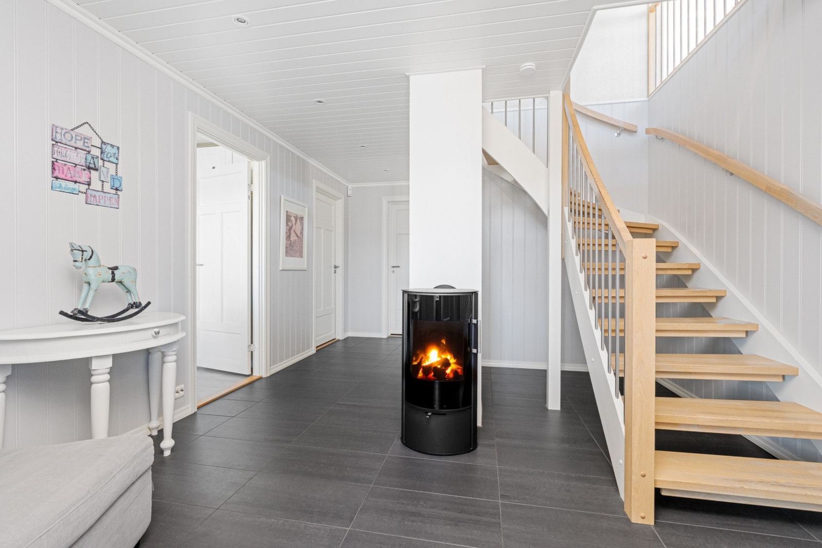 Elegant inngangsparti med moderne peis og flott trappeløsning - et hjem med særpreg fra første steg. Galleribilde