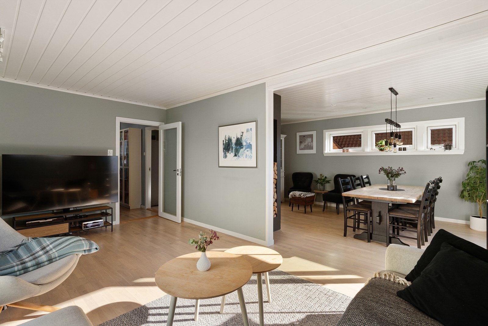 Stuen er lys og romslig etter at veggen mellom de opprinnelige stuene ble fjernet. Gulvet har parkett, og himlingen har malte panelplater. Galleribilde