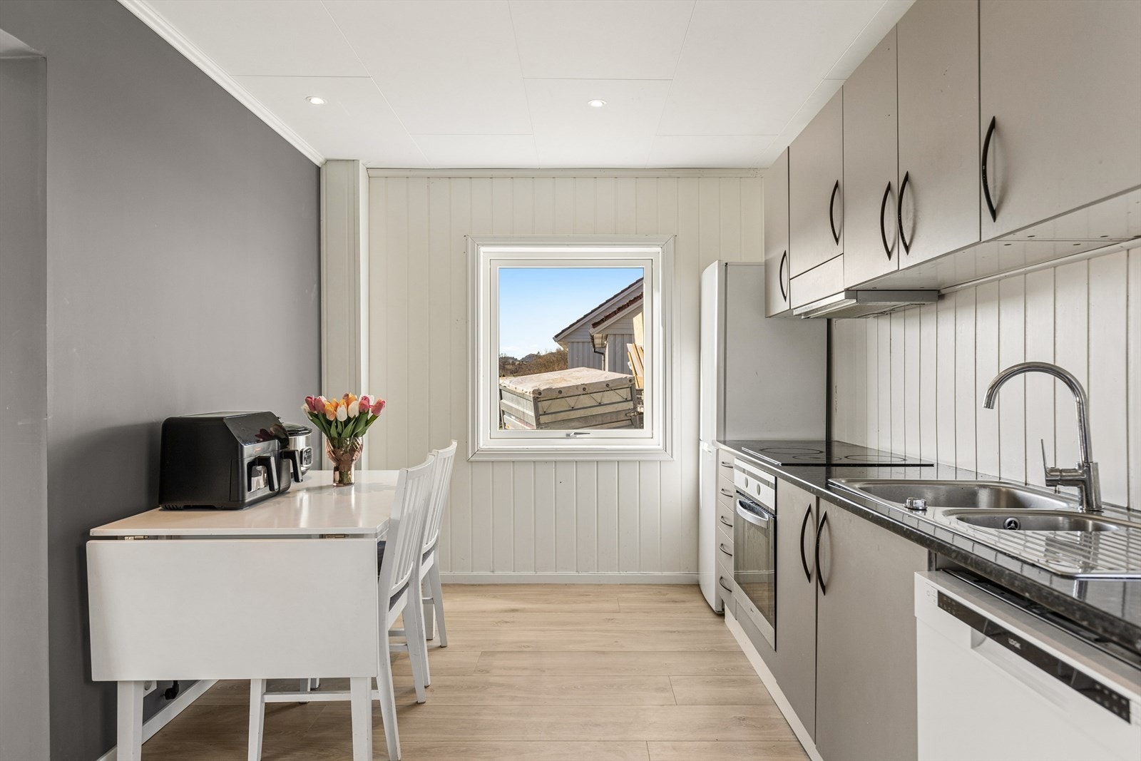 Funksjonelt kjøkken med kjøl/fryseskap, oppvaskmaskin, platetopp og stekeovn. Galleribilde
