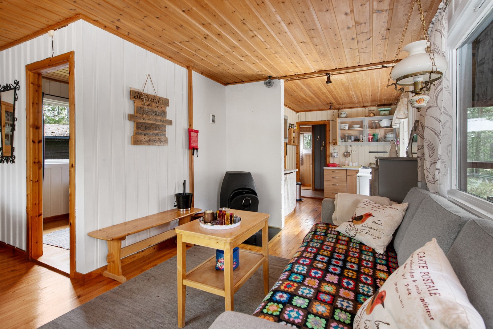 Vedovn bidrar med både varme og ekstra hygge på kjølige dager og de store vindusflatene slipper inn godt med naturlig lys og gir fin kontakt med naturen rundt hytta. Galleribilde