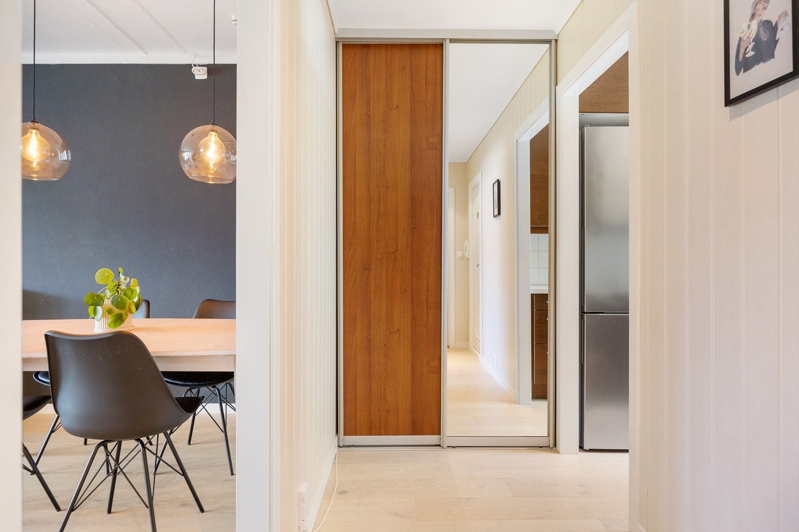 Her kan man enkelt holde orden med både knagger og en praktisk skyvedørsgarderobe med speil, som også bidrar til å gi rommet en følelse av ekstra romslighet. Galleribilde