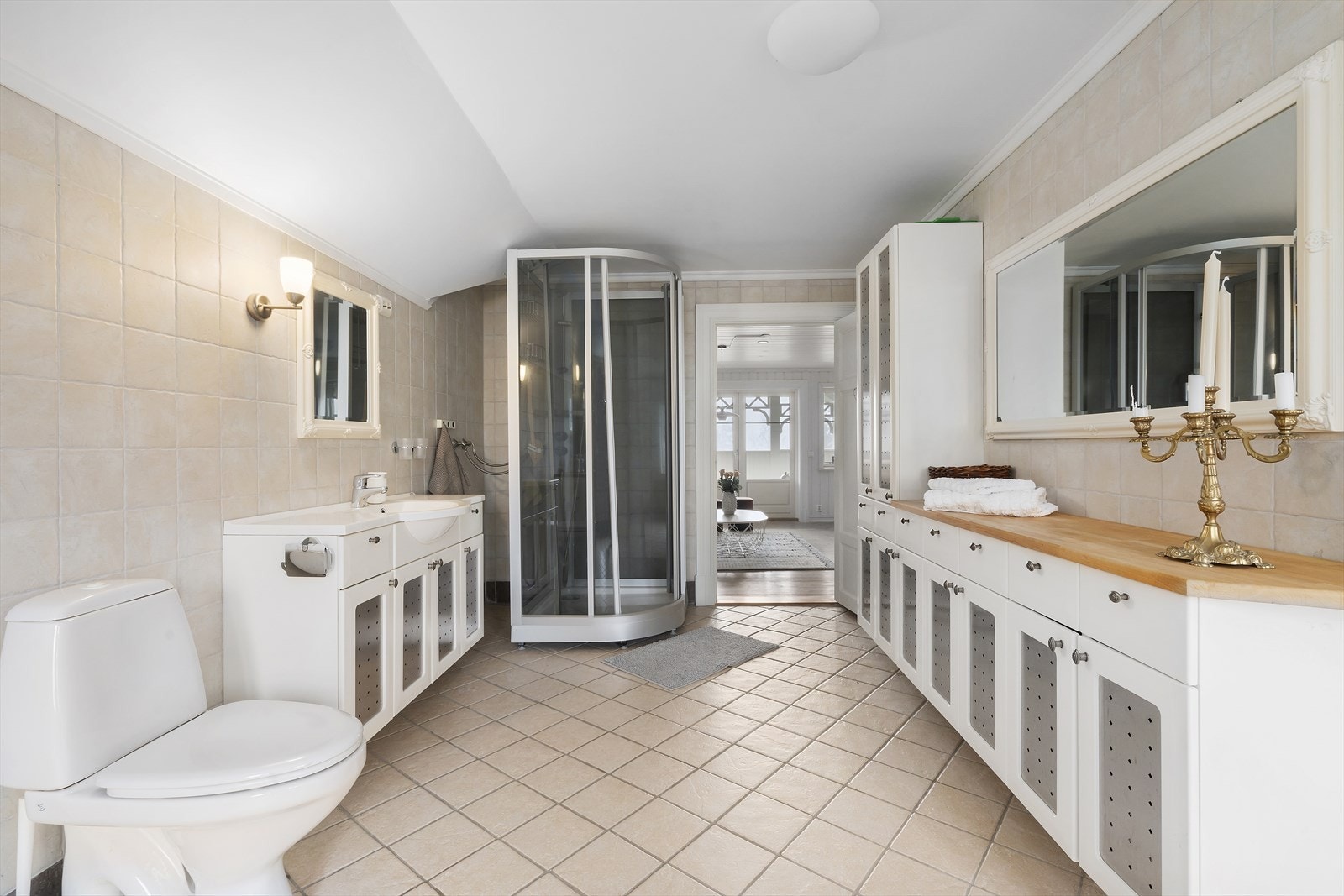 Badet er innredet med servantinnredning, god plass til oppbevaring i skapløsning, dusjkabinett, toalett og badekar. Galleribilde