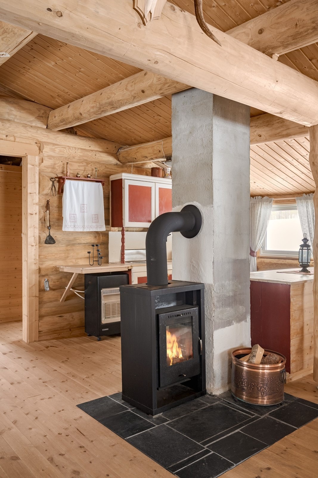 Som et fint midtpunkt i rommet er det en peisovn med glassdør som både gir god varme og bidrar til ekstra hygge. Galleribilde