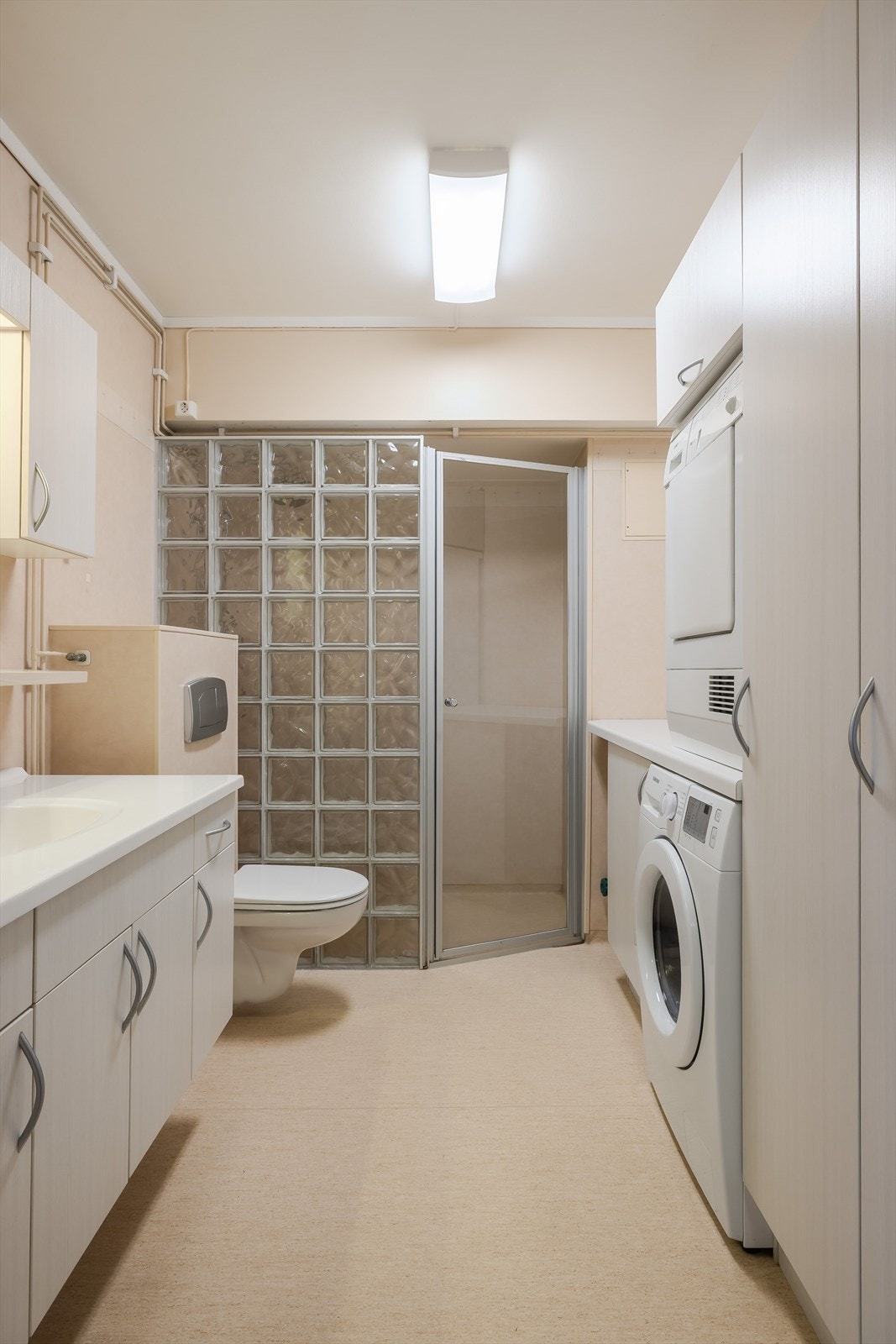 Badet er stort og er utstyrt med blant annet et svært romslig dusjhjørne. vegghengt toalett, opplegg til vaskemaskin og tørketrommel. Galleribilde