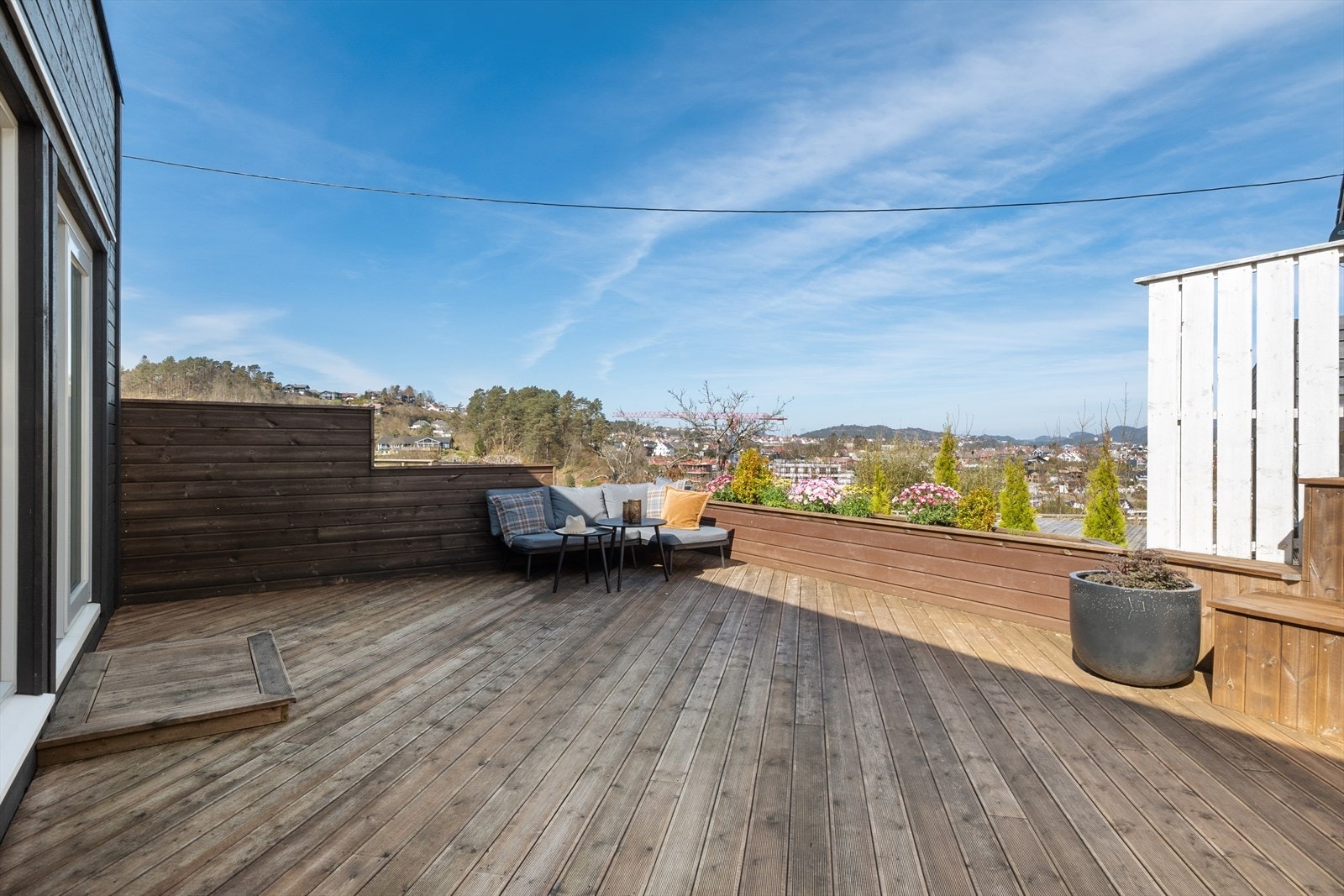 En ekstra stor terrasse med Møre Royal terrassebord med flere soner, perfekt for både avslapning og sosiale sammenkomster. Galleribilde